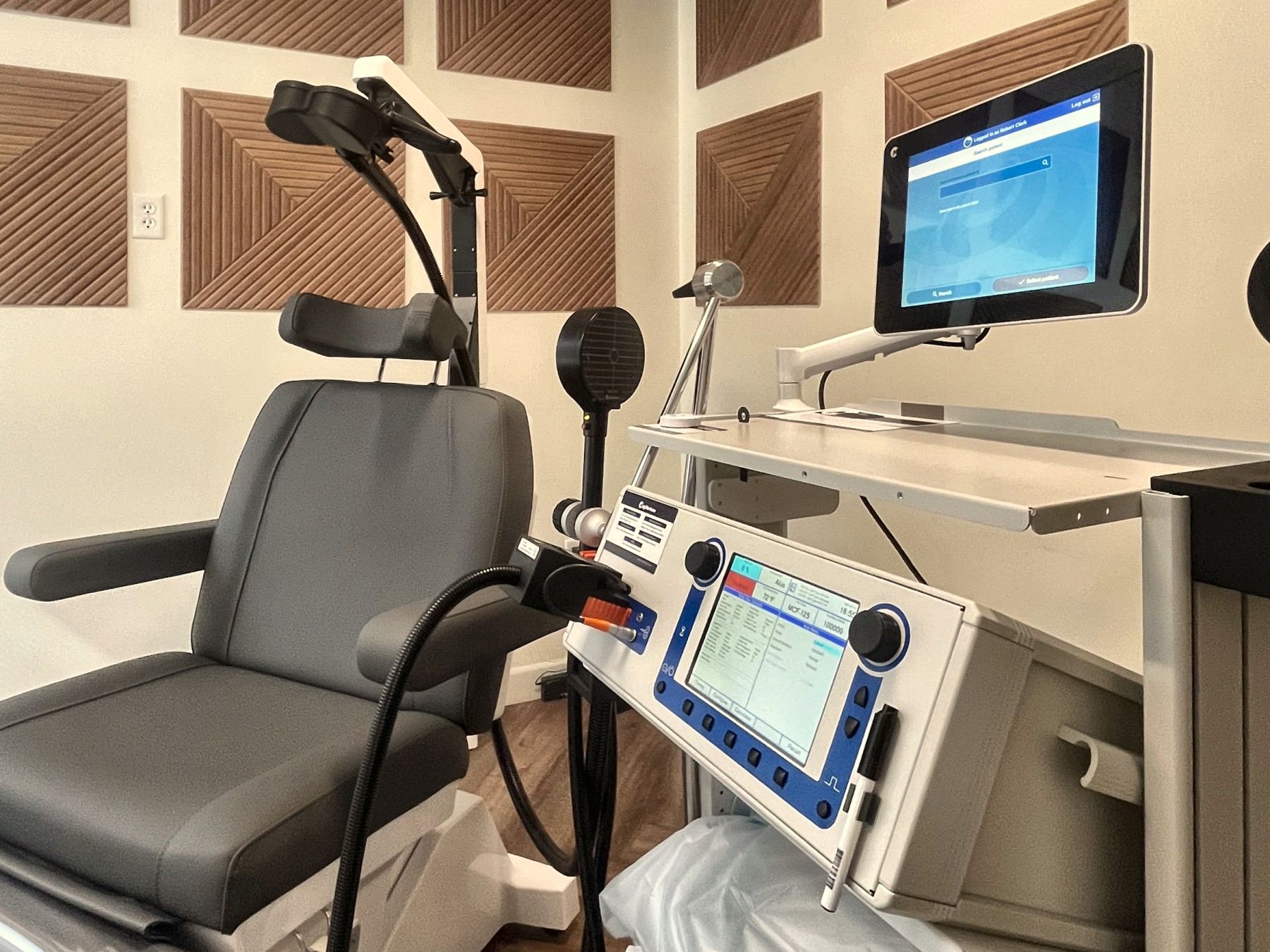 The TMS stimulator console and provider screen next to the treatment chair.