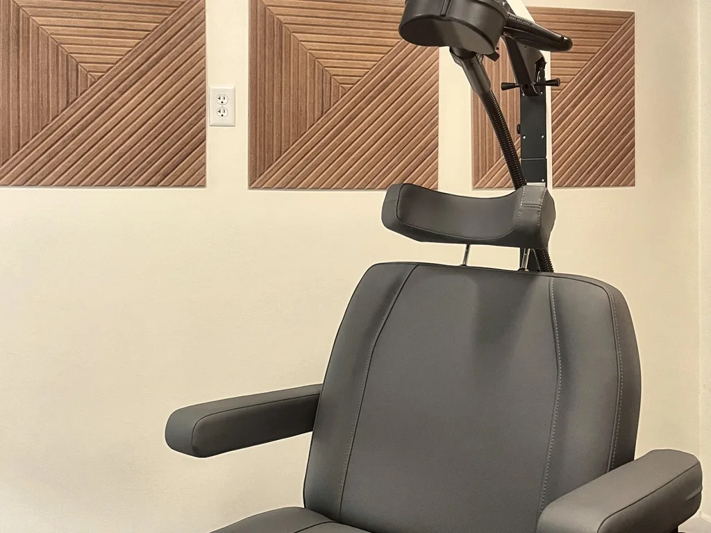 The TMS chair at our Dallas clinic, with the cushioned treatment coil positioned above the headrest.